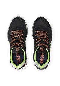 Scarpe da ginnastica nere con lacci arancioni, caratterizzate da una tomaia testurizzata, accenti verde neon all'interno e etichette "SINISTRO" e "DESTRA" sulle suole interne.