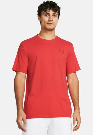 Camiseta roja de tejido suave con cuello redondo, mangas cortas y un sutil logo de Under Armour en un tono más oscuro en el pecho.