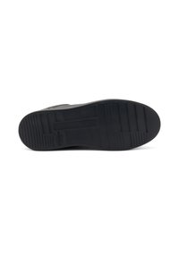 Suela de sneaker negra con goma texturizada, que presenta surcos para tracción y una superficie plana para un agarre estable.