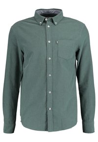 Camicia verde a maniche lunghe in tessuto morbido, con colletto a bottoni, tasca frontale e bottoni bianchi per la chiusura.