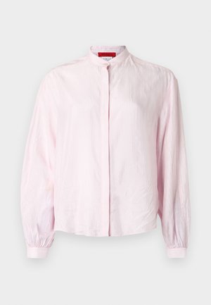 Lichtroze blouse met een mandarijnkraag, lange pofmouwen en verticale textuur. Knopenrij aan de voorkant, gemaakt van een gladde stof.