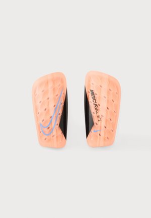 Ζευγάρι πορτοκαλί-ροδακινί επιγονατίδες Nike Mercurial Lite με μπλε λογότυπα swoosh και μαύρο εσωτερικό επένδυση σε απλό φόντο.