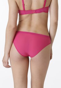Set di biancheria intima rosa con una texture liscia e elasticizzata, design a vita bassa e dettagli di cucitura minimi. Spalline regolabili sul reggiseno.