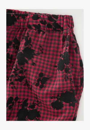Checkered fabric in red and black with floral pattern; features an elastic waistband and smooth texture.