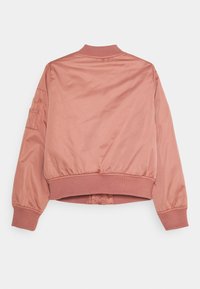 Lyserød bomberjakke lavet af glat stof, med ribbet krave og manchetter, en tætsiddende talje og en lomme på venstre ærme.