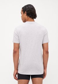 T-shirt en coton gris à manches courtes avec col rond, présentant une coupe droite et une texture douce, affiché de dos.