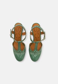 Green leather sandals with open toe and heel, ankle strap, perforated design, and decorative white stitching on the sole.