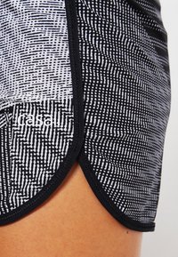 Svartvita mönstrade träningsshorts med en strukturerad design, som har en böjd nederkant och kontrasterande svart trim.