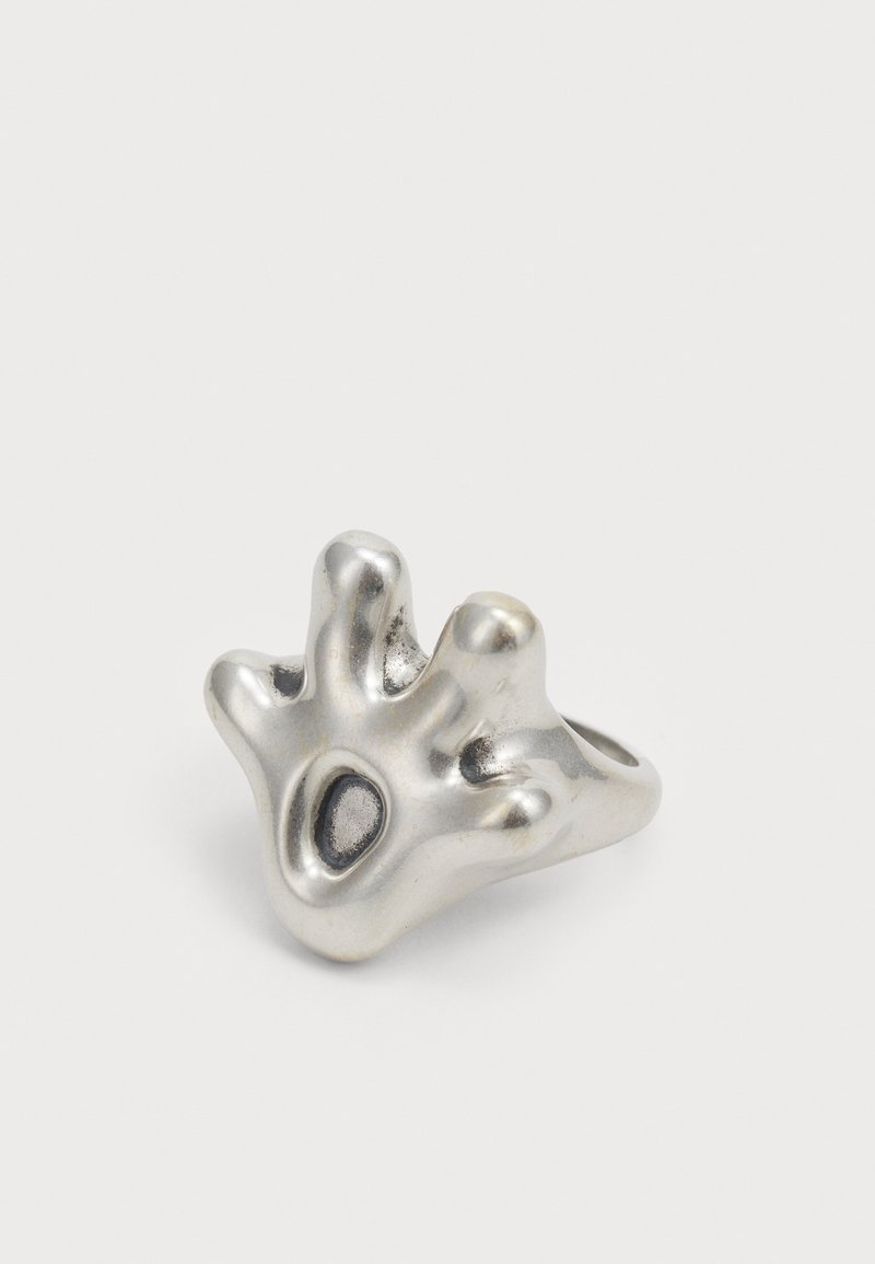 Ασημένιο δαχτυλίδι σε σχήμα χεριού με πέντε στρογγυλά "δαχτυλάκια", διαθέτοντας υφή και οβάλ λεπτομέρεια στην επιφάνειά του.