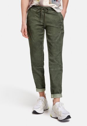 Un pantalon slim-fit de couleur vert olive avec taille élastique, poches latérales et ourlets roulés. Le tissu a une texture lisse et légèrement brillante.