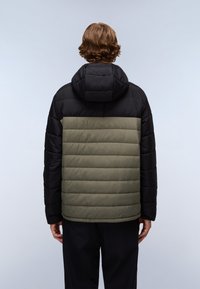 Giacca a collo alto imbottita con parte superiore nera e parte inferiore verde oliva, dotata di un ampio cappuccio e una texture trapuntata. La vista posteriore mostra pannelli orizzontali.