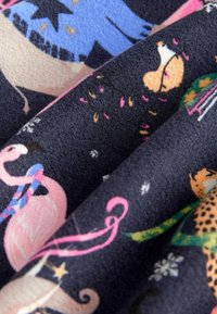 Fleece-tyg med en mörk bakgrund som har livliga, fantasifulla mönster av djur som flamingor och leoparder i olika färger.