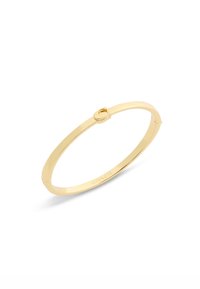 Bracciale rigido in tono oro con un design liscio e piatto e una piccola chiusura circolare. Presenta un'incisione del marchio sul lato interno.