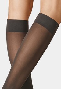 Black opaque thigh-high stockings with a wide elastic band at the top. Smooth texture and sheer finish extend from mid-thigh down.