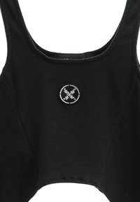 Top corto negro hecho de algodón texturizado, con tirantes anchos y un parche de logo redondo en el centro. Bordes suaves y diseño ajustado.