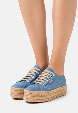 Denim platform sneakers with beige laces, round toe, and natural rope detailing around the sole. The upper is blue denim fabric.