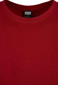Tricou din bumbac roșu cu guler rotund și mâneci scurte. Dispune de un guler ribetat și etichetă cu inscripția "URBAN CLASSICS", mărimea M.