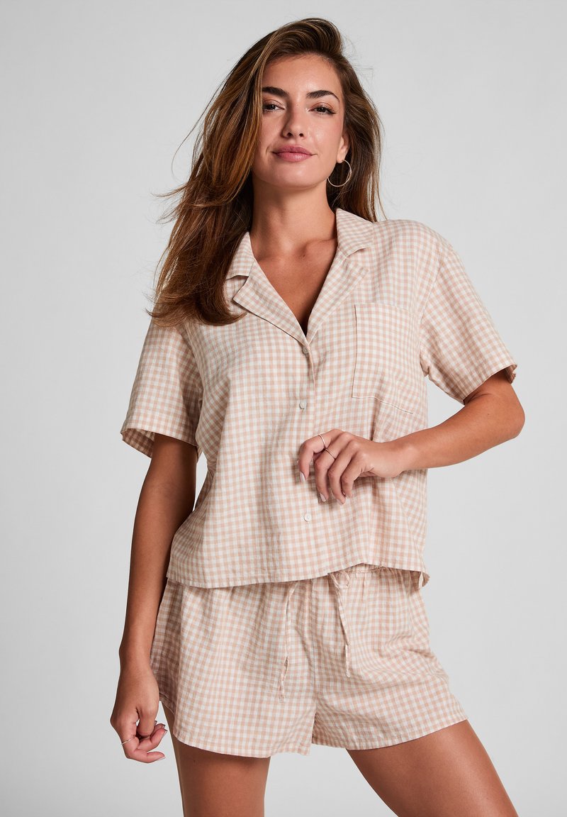 Korte mouwen, gekleed pyjama set in een lichtbeige ruitpatroon, met een knoopsluiting aan de voorkant en shorts met elastische tailleband. Zachte, gestructureerde stof.
