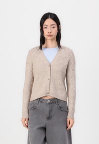 Beige knitted cardigan with a ribbed texture, V-neckline, and button closure. Features long sleeves and a slightly cropped design.