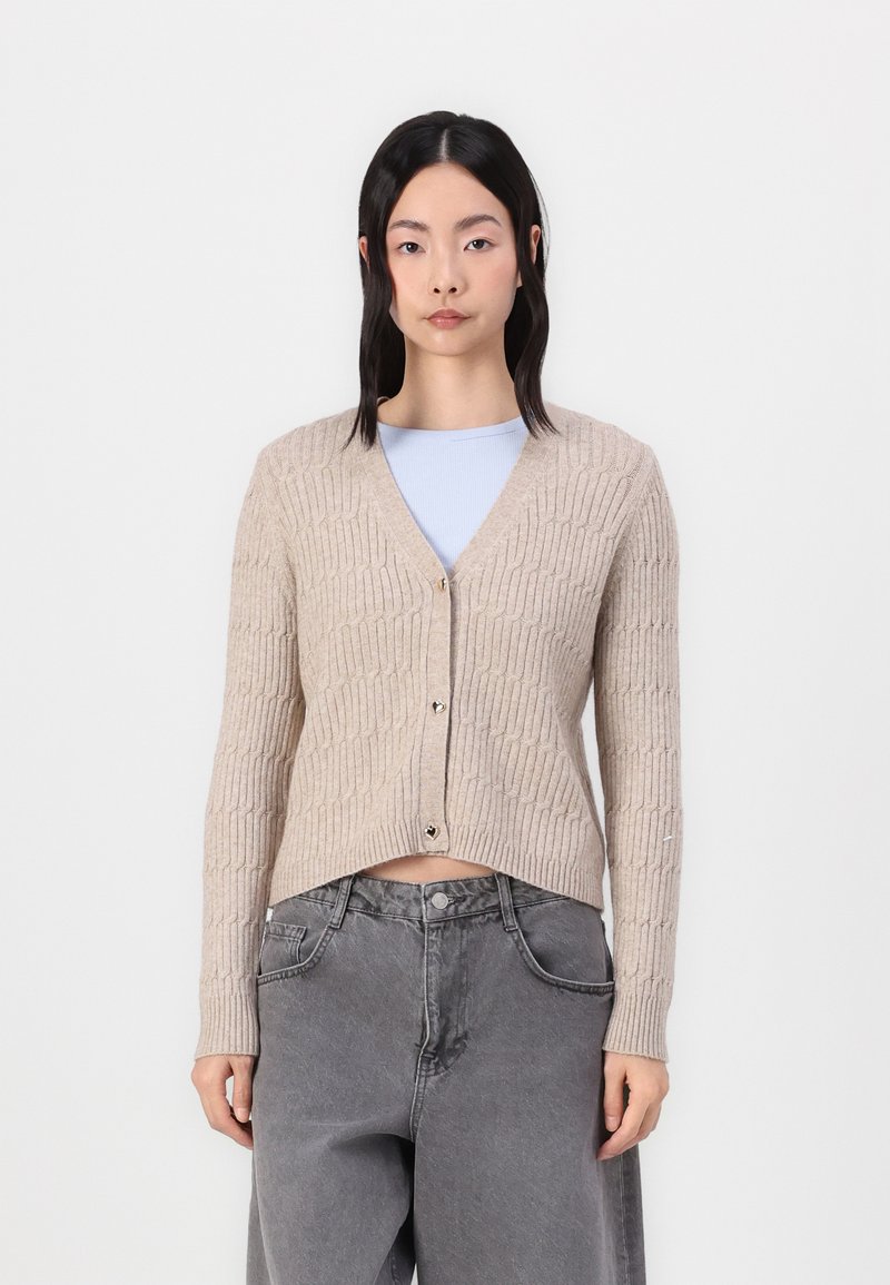 Beige knitted cardigan with a ribbed texture, V-neckline, and button closure. Features long sleeves and a slightly cropped design.