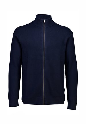 Navy sininen vetoketjupaltta, joka on valmistettu neulekankaasta. Siinä on korkea kaulus ja pitkät hihat, sileä pinta ja täyspitkä vetoketju edessä.