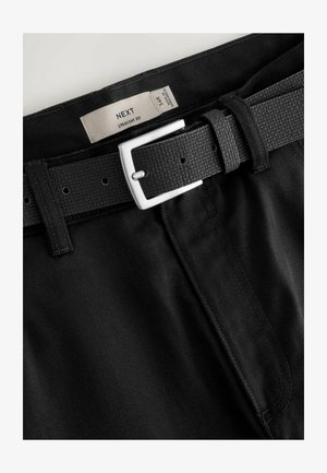 Mustad sirge lõikega püksid musta tekstuuriga vöö ja hõbedase sanga ning suuruse 34R etikett. Kangas sisaldab peeneid diagonaallõikeid.