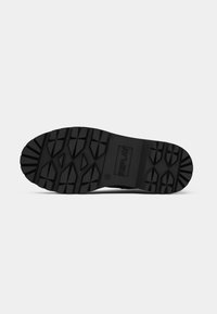 Semelle de chaussure en caoutchouc noir avec un motif de grip texturé, arborant un logo REPLAY rectangulaire et un design de semelle distinct pour une meilleure traction.