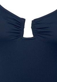 Temno modra kopalna majica z nagubanjem na izrezu in odprtinami. Narejena iz gladkega, raztegljivega materiala.