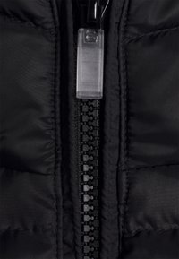 Svart isolerad jacka med detaljer som en vertikal dragkedja med en genomskinlig dragflik, quiltat mönster och slät tygfinish.