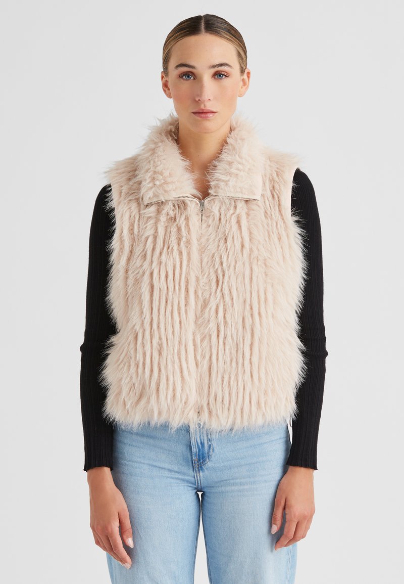 Faux-Fur-Weste mit Kragen in Hellrosa. Verfügt über einen Reißverschluss und gerippte schwarze lange Ärmel. Weiche, strukturierte Oberfläche. Denim-Jeans.