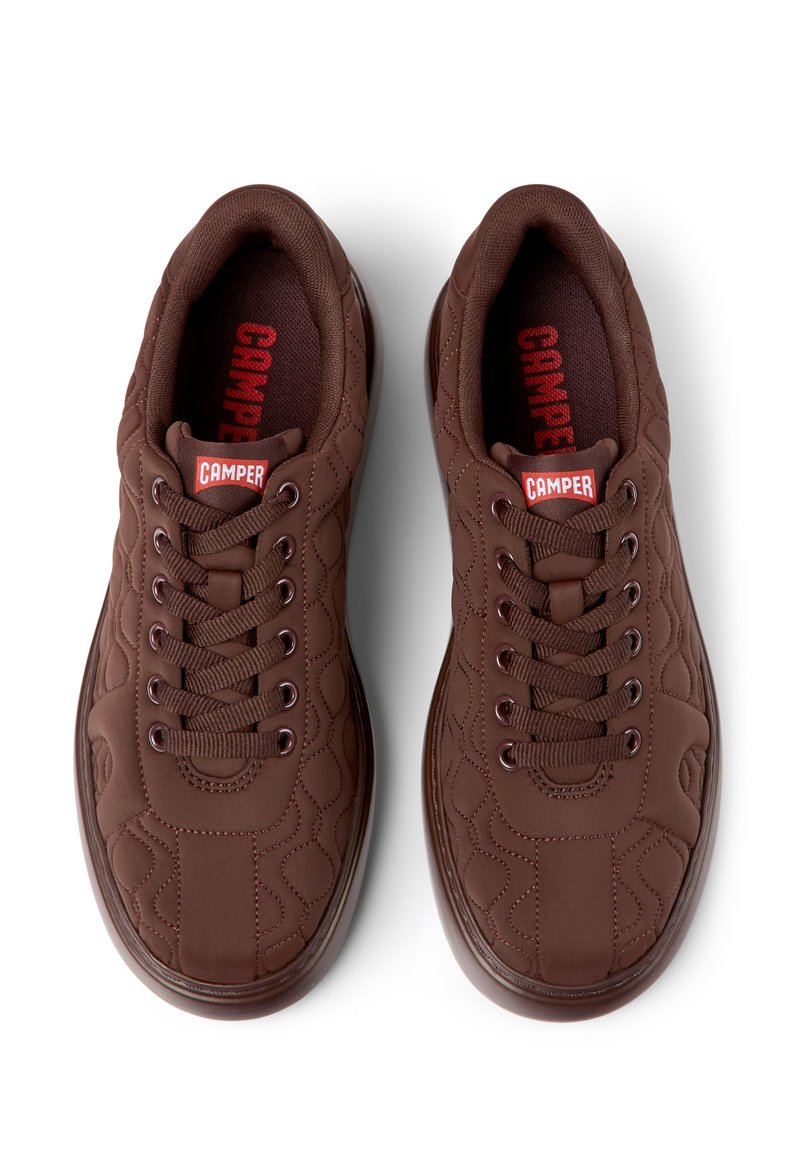 Sneaker camper marroni con un design trapuntato testurizzato, punta rotonda, sei occhielli per i lacci e accenti rossi sul linguettone e sulla soletta.