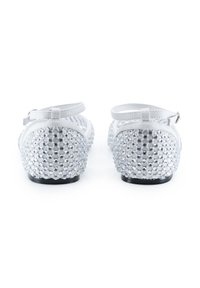 Weiße Ballerinas im geschmückten Design, mit runden, klaren Strasssteinen auf der Rückseite und einem einfachen Knöchelriemen. Schwarze Sohle.