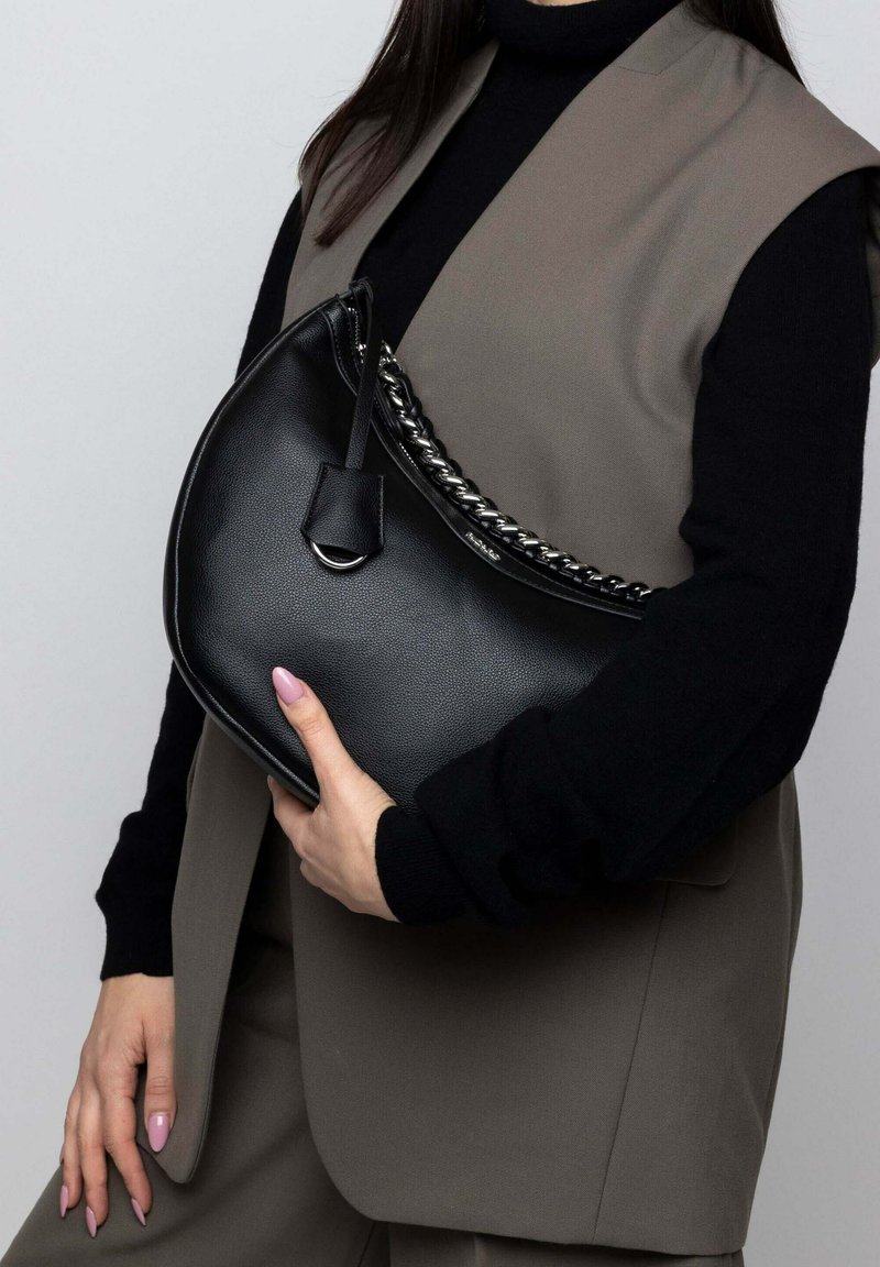 Borsa in pelle nera con forma curva, dotata di tracolla in catena intrecciata e un piccolo cartellino. Texture liscia con un sottile motivo a grana.