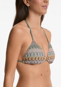 Trekantig bikinitopp i flerfärgad mönstrad tyg. Har tunna gröna remmar och en strukturerad väv, med blommotiv och vågmönster.