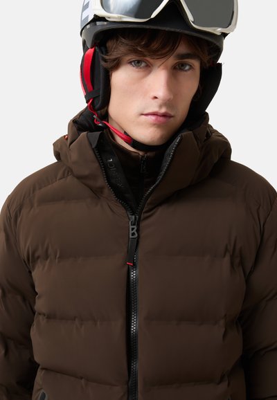 Brown puffer jacket with a high collar, featuring a black front zipper, red accents, and a smooth, quilted texture.