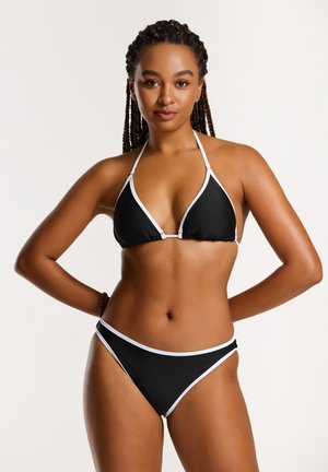 Juodas bikini komplektas su trikampiu halter stiliumi ir baltu apvadu bei suderintais žemais kelnaitėmis; lygus paviršius ir elegantiškas dizainas.