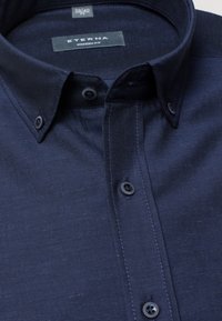 Chemise boutonnée bleu marine d'Eterna avec une coupe moderne, dotée d'un col structuré et de boutons assortis, fabriquée à partir d'un tissu texturé.