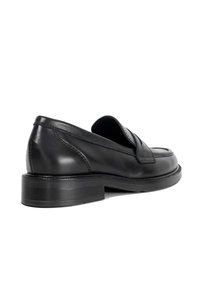 Black leather loafers with a low block heel, a rounded toe, and stitched detailing along the edges. Smooth texture, minimal design.