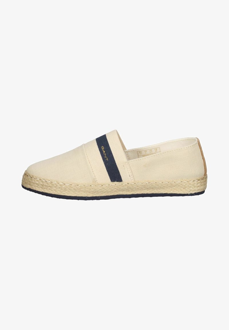 Espadrillas in tela beige con una fascia elastica blu e suola in juta intrecciata. Presentano un'etichetta nella parte superiore e una suola nera.