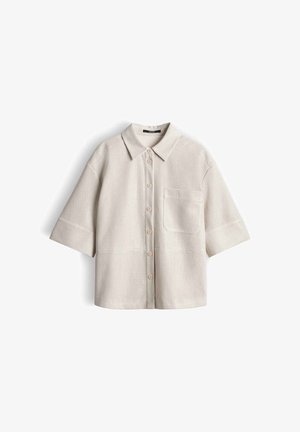 Beige short-sleeve button-up shirt with a pointed collar, front chest pocket, and textured waffle knit fabric.