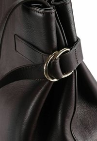 Braune Ledertasche mit plissiertem Design, die ein goldenes Ringdetail an einem Riemen zeigt und eine strukturierte Oberfläche aufweist.