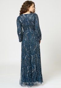 Langes, fließendes dunkelblaues Kleid mit durchsichtigen Ärmeln, das mit goldenen und silbernen floralen Verzierungen sowie kunstvollen Perlenmustern geschmückt ist.