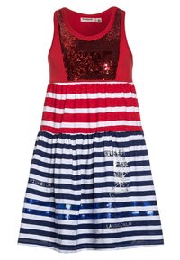 Punast tank-kleiti, millel on säraaktsentiga pluus, mis sisaldab horisontaalseid punaseid ja valgeid ridasid ülaserval ning tumesiniseid ja valgeid ridasid seeliku osas.