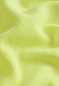 Svetlo rumena tkanina z gladko teksturo in rahlim raztezanjem, s pletenim tkanjem, ki ji daje mehak in prožen videz.