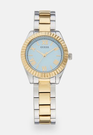 Montre en métal doré et argenté avec un cadran bleu, des marqueurs en chiffres romains et une lunette cannelée. Dotée d'un bracelet à maillons.