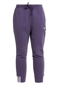 Lila sweatpants gjorda av en bomullsblandning, med dragsko i midjan, avsmalnande ben och vita accentremsor vid mudden.