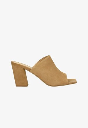 Beige Wildledermules mit offenem Zehenbereich, breiter Vorderseite, schrägem Schnitt und Blockabsatz. Merkmale sind eine glatte Textur und eine zeitgemäße Silhouette.