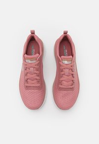 Rosa träningsskor med en texturerad mesh-överdela, vadderad tunga, förstärkt snörning och en lätt, dämpad sula.