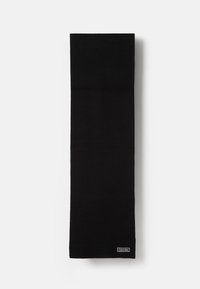 Écharpe noire à côtes fabriquée en tissu doux. Design long et étroit avec une petite étiquette en blanc portant le logo Calvin Klein cousue à une extrémité.