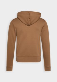 Sweat à capuche marron à manches longues, avec une texture douce et une taille ajustée. Les coutures décoratives sur la capuche renforcent le design.
